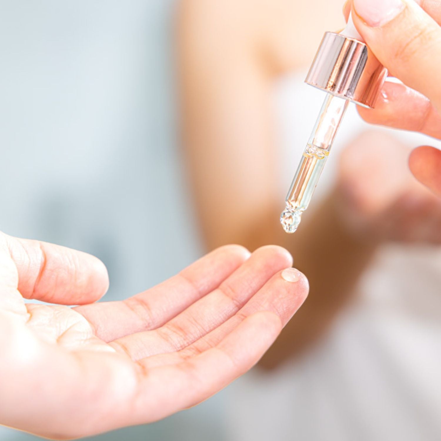 Applying lightweight eye oil with dropper showing fast absorbing texture for mature skin to hydrate smooth fine lines and improve elasticity