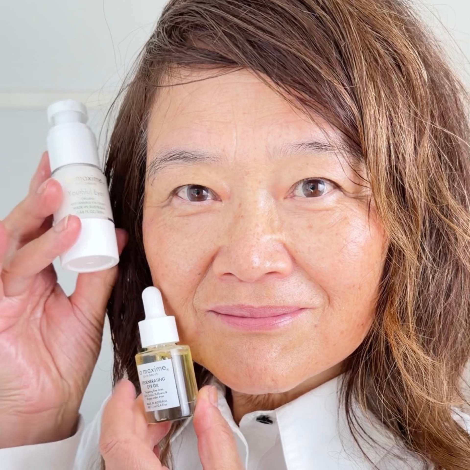 Founder of LA MAXIME holding eye cream showing real results for mature skin including reduced wrinkles and brighter under-eye area